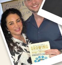 Jake Randolph with a client holding the Growing Your Beauty Business book